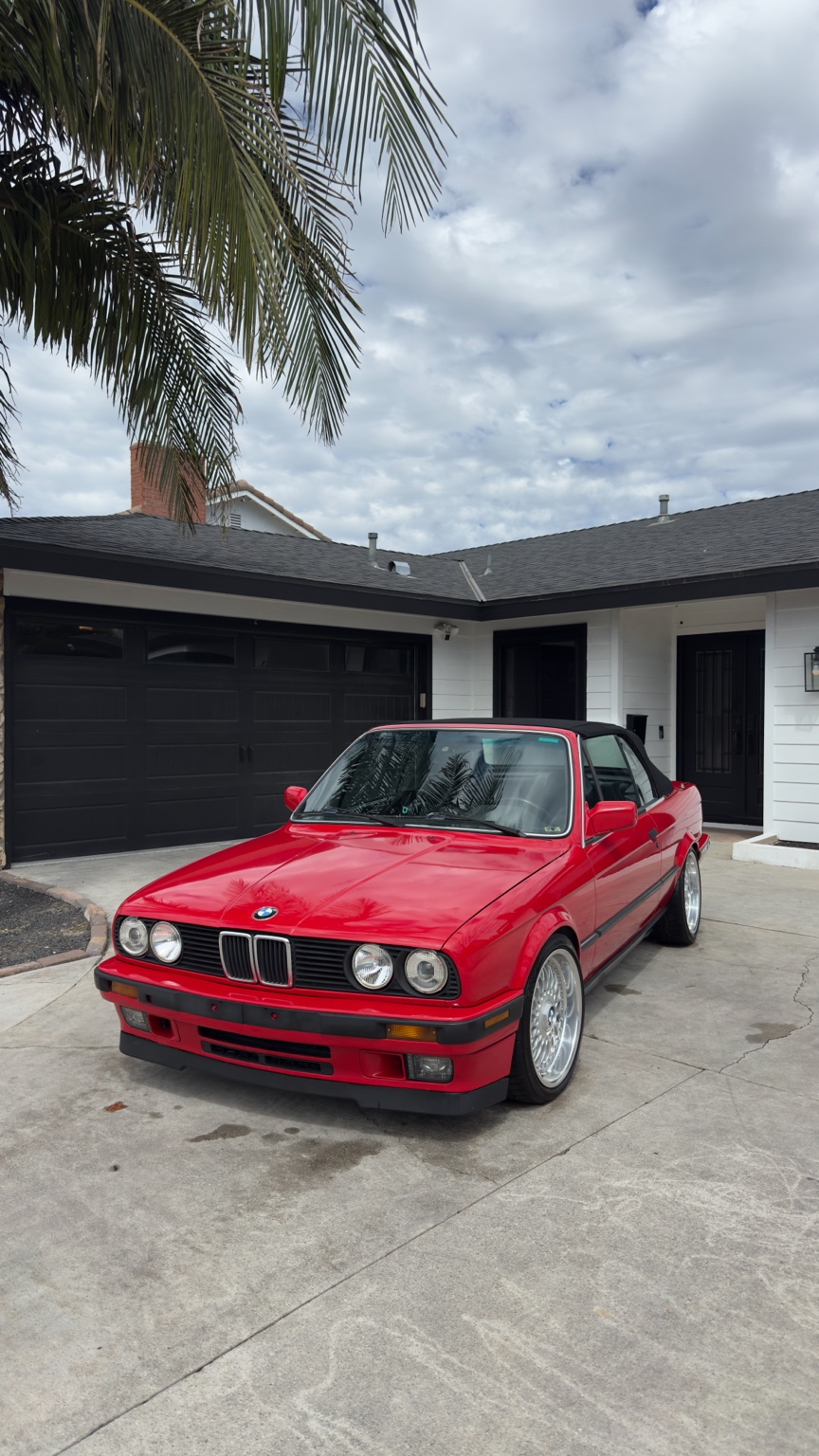 Red classic BMW convertible in a driveway